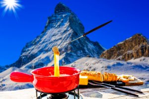 Fondue cheese, swiss winter ski holidays break for lunch, mountain view Matterhorn in Zermatt, Switzerland.