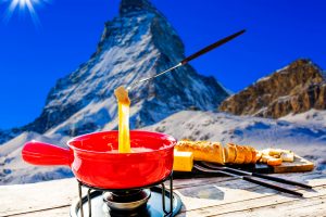 Fondue cheese, swiss winter ski holidays break for lunch, mountain view Matterhorn in Zermatt, Switzerland.