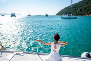 Portrait of Caucasian woman enjoy luxury lifestyle catamaran boat sailing and looking at beautiful nature sea in summer sunny day. Beauty female relax outdoor activity on tropical travel vacation trip